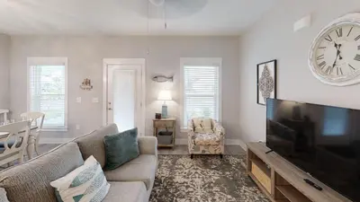 a living room with a large flat screen tv at Seabreeze 114 in Panama City Beach