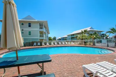 a pool with an umbrella and chairs and a table and chairs at Beachside Villas 732- Southbound Serenity in Santa Rosa Beach