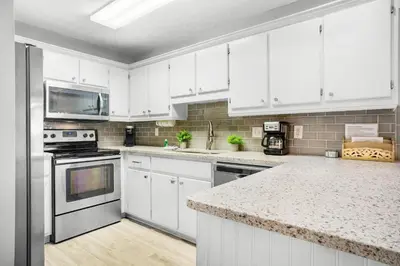 a kitchen with white cabinets and a counter top at Beachside Villas 732- Southbound Serenity in Santa Rosa Beach