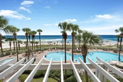 a view of the pool and beach from the balcony of a resort at Grand Panama 1-305 in Panama City Beach