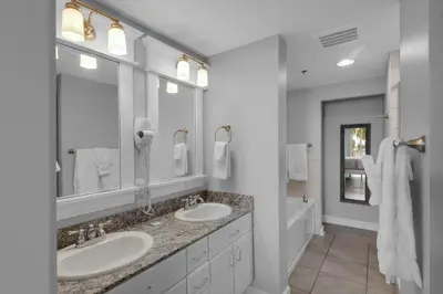 a white bathroom with two sinks and a tub at Grand Panama 1-305 in Panama City Beach
