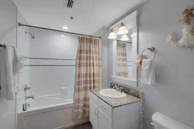 a white bathroom with a sink and a tub and a toilet at Grand Panama 1-305 in Panama City Beach