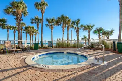 a small swimming pool with palm trees in the background at Grand Panama 1-305 in Panama City Beach