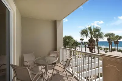 a balcony with a table and chairs and a view of the beach at Grand Panama 1-305 in Panama City Beach