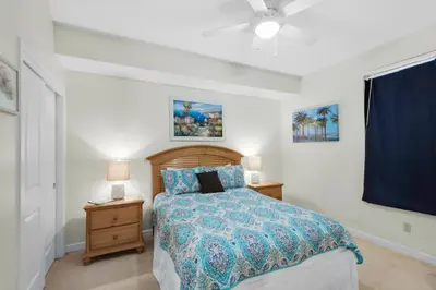 a bedroom with a bed with a blue comforter at Marisol 501 in Panama City Beach