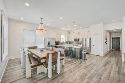 a kitchen and dining room with a table and chairs at Holiday Fin - Heated Pool & Hot Tub! Game Tables! Beachfront!!! in Panama City Beach