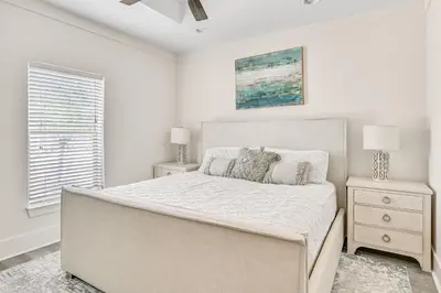 a white bedroom with a large bed and a window at Holiday Fin - Heated Pool & Hot Tub! Game Tables! Beachfront!!! in Panama City Beach