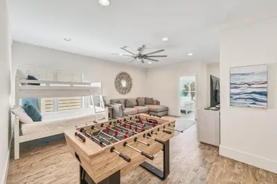a living room with a foosball table at Holiday Fin - Heated Pool & Hot Tub! Game Tables! Beachfront!!! in Panama City Beach