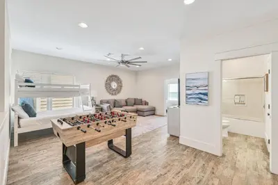 a living room with a foosball table and a bunk bed at Holiday Fin - Heated Pool & Hot Tub! Game Tables! Beachfront!!! in Panama City Beach