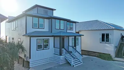 a house with a staircase in front of it at Making Waves - Huge Heated Beachfront Pool & Hot Tub! Best In Pcb! in Panama City Beach