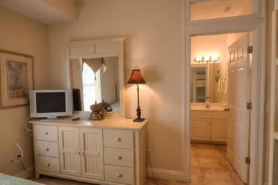 a room with a dresser with a television on it at Surf Song - Beachfront Home With Swimspa! in Panama City Beach