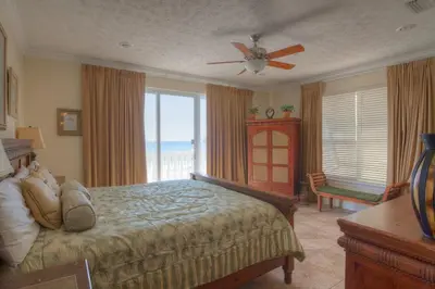 a bedroom with a bed with a view of the ocean at Surf Song - Beachfront Home With Swimspa! in Panama City Beach
