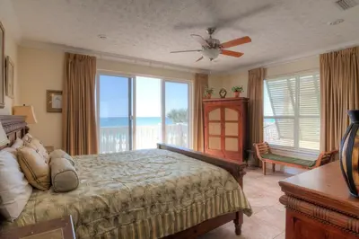 a bedroom with a bed with a view of the ocean at Surf Song - Beachfront Home With Swimspa! in Panama City Beach