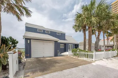 a blue house with a white fence and palm trees at Fantasea - Wonderful Private Beachfront Home - Beautiful!!! in Panama City Beach