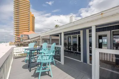 a deck with blue chairs and a table on a building at Fantasea - Wonderful Private Beachfront Home - Beautiful!!! in Panama City Beach