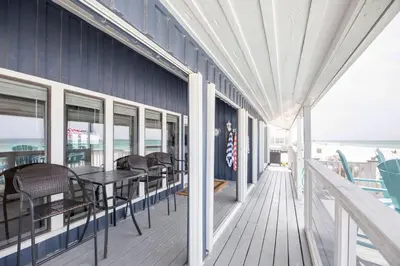 a porch with chairs and tables on a building at Fantasea - Wonderful Private Beachfront Home - Beautiful!!! in Panama City Beach