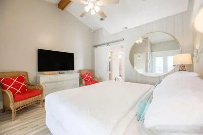 a bedroom with a white bed and a mirror at Fantasea - Wonderful Private Beachfront Home - Beautiful!!! in Panama City Beach