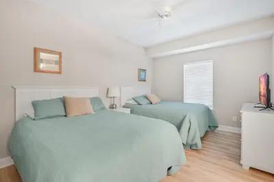 a bedroom with two beds and a ceiling fan at Cotton Sails - On The Beach - Plunge Pool! in Panama City Beach