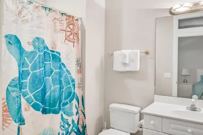 a bathroom with a sea turtle shower curtain at Cotton Sails - On The Beach - Plunge Pool! in Panama City Beach