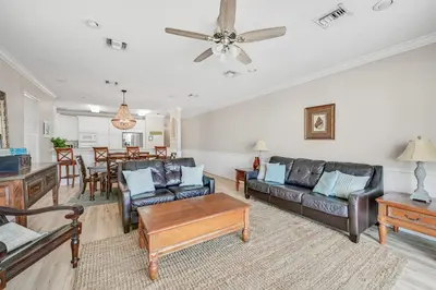 a living room with leather furniture and a dining room at Cotton Sails - On The Beach - Plunge Pool! in Panama City Beach