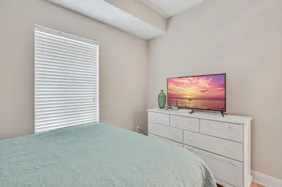 a bedroom with a bed and a television on a dresser at Cotton Sails - On The Beach - Plunge Pool! in Panama City Beach