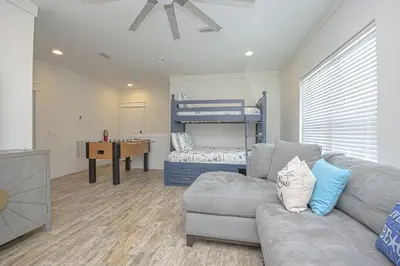 a living room with a couch and a bunk bed at The Tourist Trap - Heated Private Beachfront Pool! Gorgeous!!! in Panama City Beach