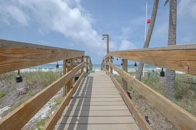 a wooden walkway leading down to the beach at The Tourist Trap - Heated Private Beachfront Pool! Gorgeous!!! in Panama City Beach