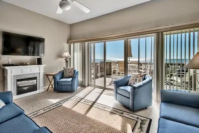 a living room with two blue chairs and a fireplace at Pugsy's Paradise Sleeps 10! in Panama City Beach