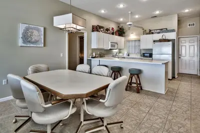 a kitchen and dining room with a table and chairs at Pugsy's Paradise Sleeps 10! in Panama City Beach