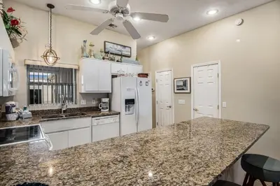 a kitchen with white appliances and granite counter tops at Pugsy's Paradise Sleeps 10! in Panama City Beach