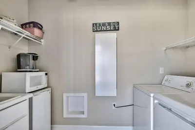 a white kitchen with a sign that reads lets do sunset at Pugsy's Paradise Sleeps 10! in Panama City Beach
