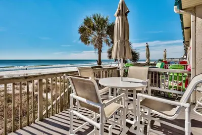 a patio with a table and chairs and the beach at Pugsy's Paradise Sleeps 10! in Panama City Beach