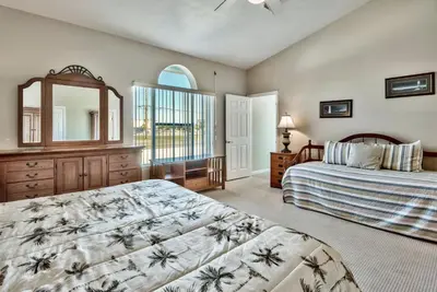 a bedroom with two beds and a mirror at Pugsy's Paradise Sleeps 10! in Panama City Beach