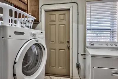 a laundry room with a washing machine and a door at Sand Blast - Lovely Beachfront Home With Tons Of Space! in Panama City Beach