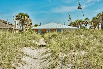 a house on the beach with tall grass at Sand Blast - Lovely Beachfront Home With Tons Of Space! in Panama City Beach