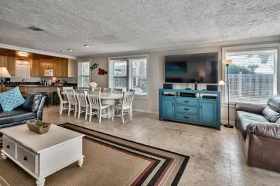 a living room with a blue cabinet and a table at Sand Blast - Lovely Beachfront Home With Tons Of Space! in Panama City Beach