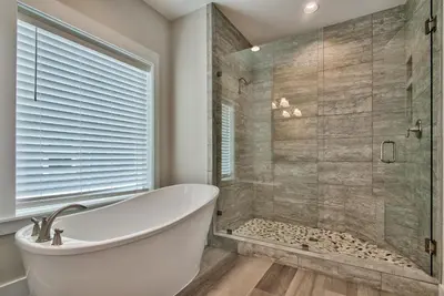 a bathroom with a tub and a glass shower at Hook, Wine & Sinker - Private Pool! Brand New! in Panama City Beach