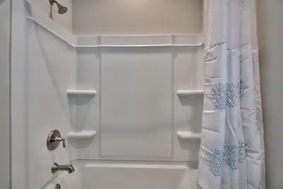 a bathroom with a shower with a white shower curtain at Hook, Wine & Sinker - Private Pool! Brand New! in Panama City Beach
