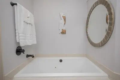 a white bathroom with a tub and a mirror at Island Time- Wonderful Private Beachfront Home - Beautiful!!! in Panama City Beach