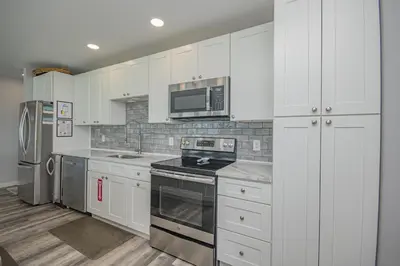 a kitchen with white cabinets and a stove top oven at Island Time- Wonderful Private Beachfront Home - Beautiful!!! in Panama City Beach