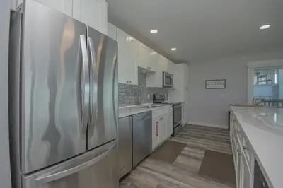 a kitchen with stainless steel appliances and white cabinets at Island Time- Wonderful Private Beachfront Home - Beautiful!!! in Panama City Beach