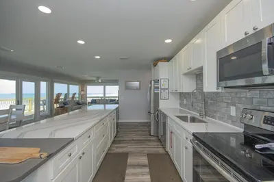 a kitchen with white cabinets and a view of the ocean at Island Time- Wonderful Private Beachfront Home - Beautiful!!! in Panama City Beach
