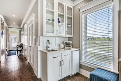 a kitchen with white cabinets and a sink and a window at Southern Comfort - Beautiful Private Beachfront Home! in Panama City Beach