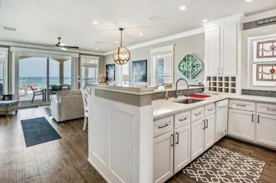 a kitchen with white cabinets and a large island at Southern Comfort - Beautiful Private Beachfront Home! in Panama City Beach