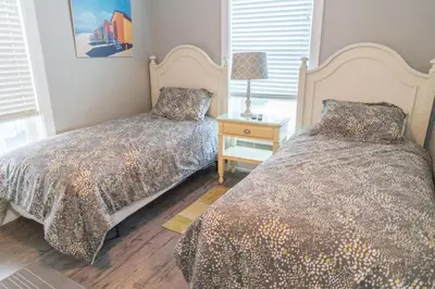 a bedroom with two beds and a table with a lamp at Southern Comfort - Beautiful Private Beachfront Home! in Panama City Beach