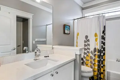 a bathroom with a sink and a toilet and a mirror at Southern Comfort - Beautiful Private Beachfront Home! in Panama City Beach