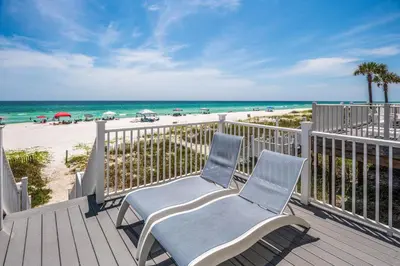 a deck with two chairs and the beach at Southern Comfort - Beautiful Private Beachfront Home! in Panama City Beach