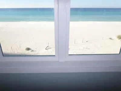 a view of the beach from a window at The Lighthouse 6 Bd Home With Beachfront Pool And Hot Tub in Panama City Beach