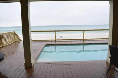 a swimming pool with a view of the beach at The Lighthouse 6 Bd Home With Beachfront Pool And Hot Tub in Panama City Beach