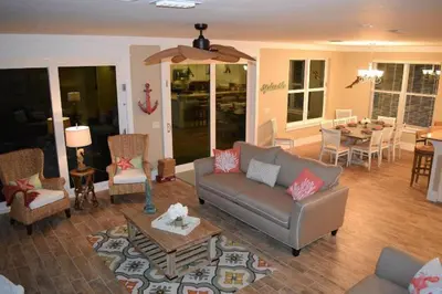 a living room with a couch and a table at The Lighthouse 6 Bd Home With Beachfront Pool And Hot Tub in Panama City Beach